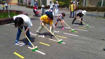 デッキブラシで地面をこする競技中